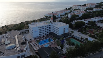 Un hotel con piscina, varios balcones y vistas al mar.