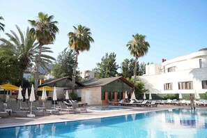 Una piscina al aire libre de temporada, sombrillas, tumbonas