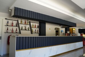 A bar area with a marble countertop and shelves of liquor bottles. - Ada Newday Resort Hotel (Kusadasi)