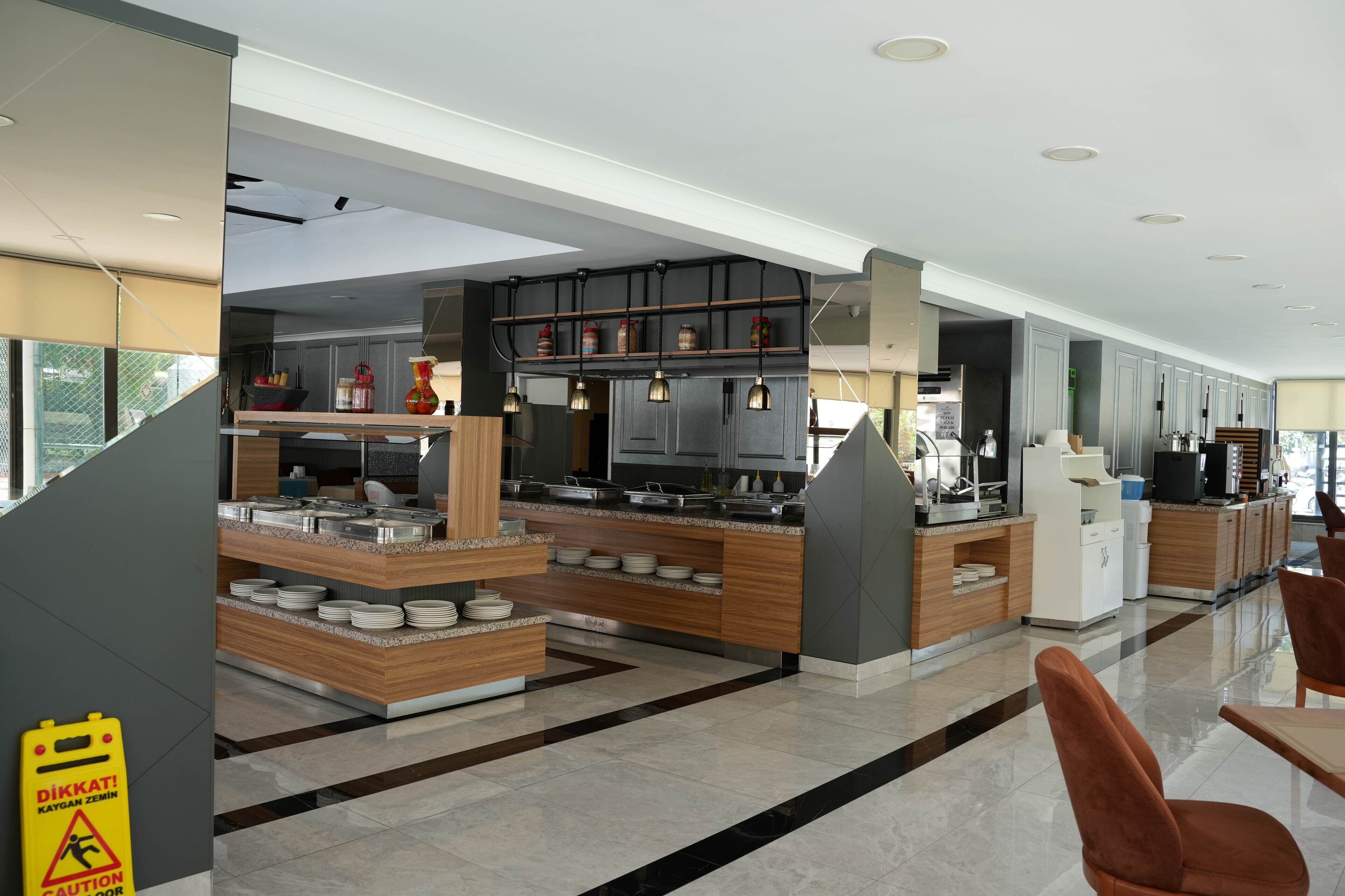 Une cuisine moderne avec des plans de travail en bois, une cuisinière intégrée et un coin repas comprenant une table et des chaises.