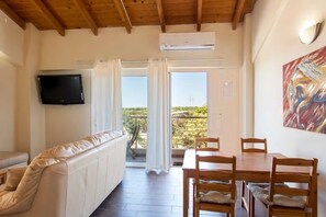 Family Apartment, 2 Bedrooms, Pool View | Living area | 43-inch flat-screen TV with premium channels, TV, books - Arion Stables & Apartments (Hersonissos)