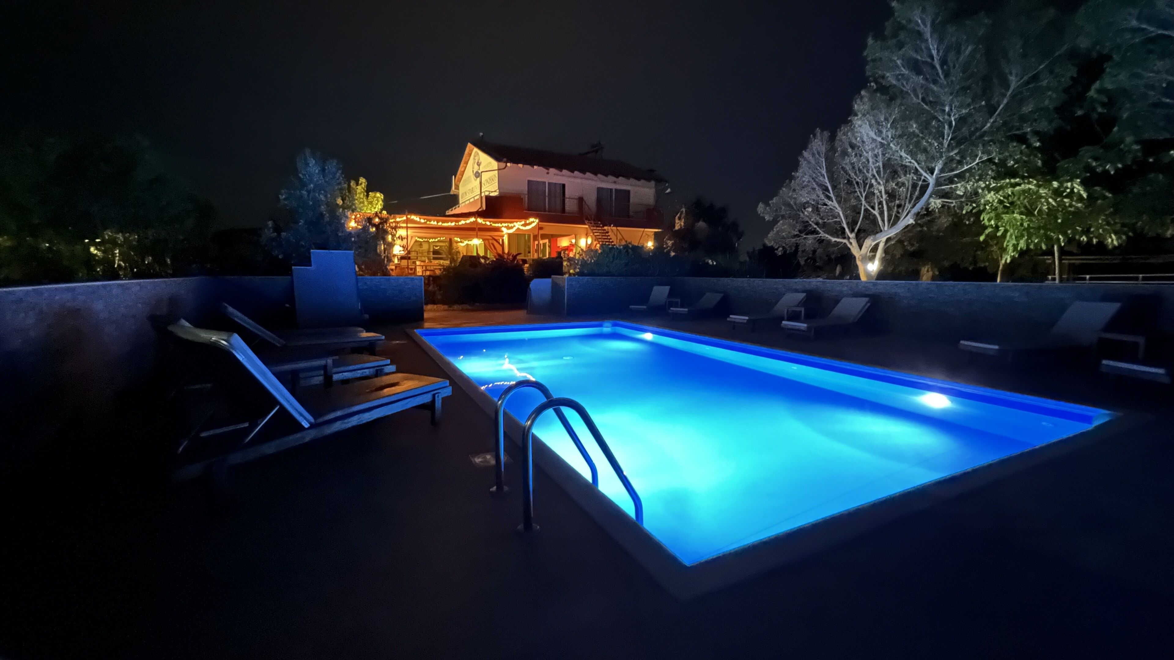 Une piscine avec des chaises longues et un bâtiment en arrière-plan.