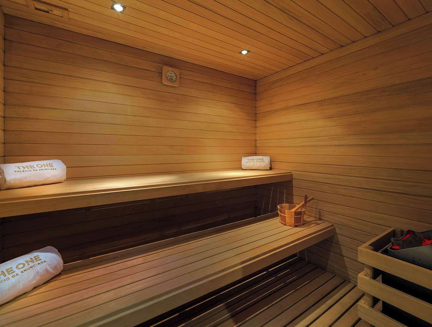 A sauna with wooden benches and a bench with a towel.