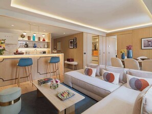 A modern living room with a sofa, coffee table, and bar area.