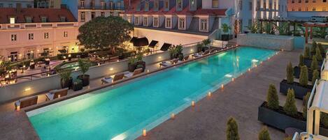 Una piscina al aire libre de temporada, tumbonas