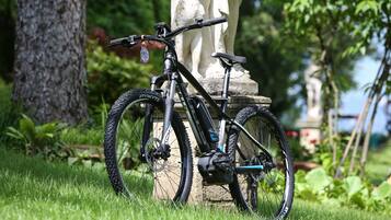 Uma bicicleta de montanha estacionada na grama perto de uma estátua de pedra.