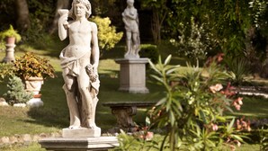 Un jardí amb estàtues i plantes en testos.