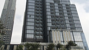 A tall, modern skyscraper with a glass facade and a prominent central spire. - Zahoo House - Vinhomes Central Park (Ho Chi Minh City)