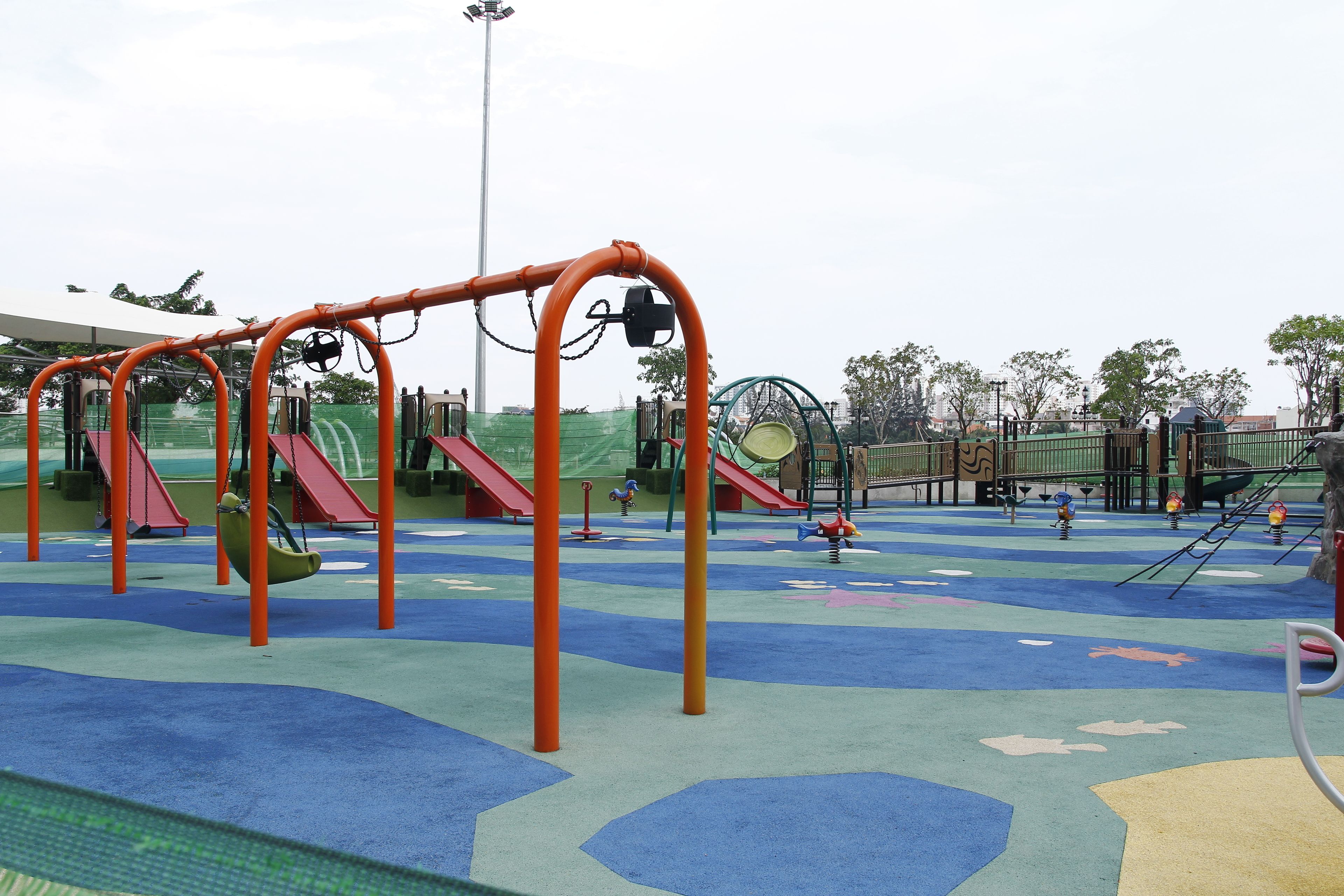 Un'area giochi con altalene, scivoli e una struttura per arrampicata.