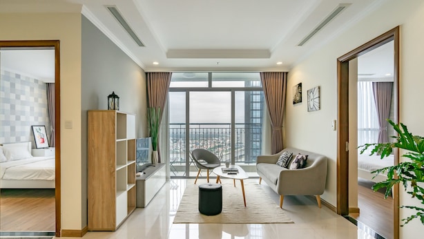 A modern living room with a sofa, coffee table, and a view of a balcony. - Zahoo House - Vinhomes Central Park (Ho Chi Minh City)