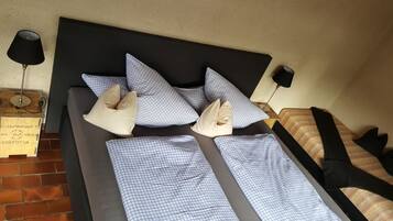 A neatly made bed with checkered bedding, a black headboard, and two bedside lamps.