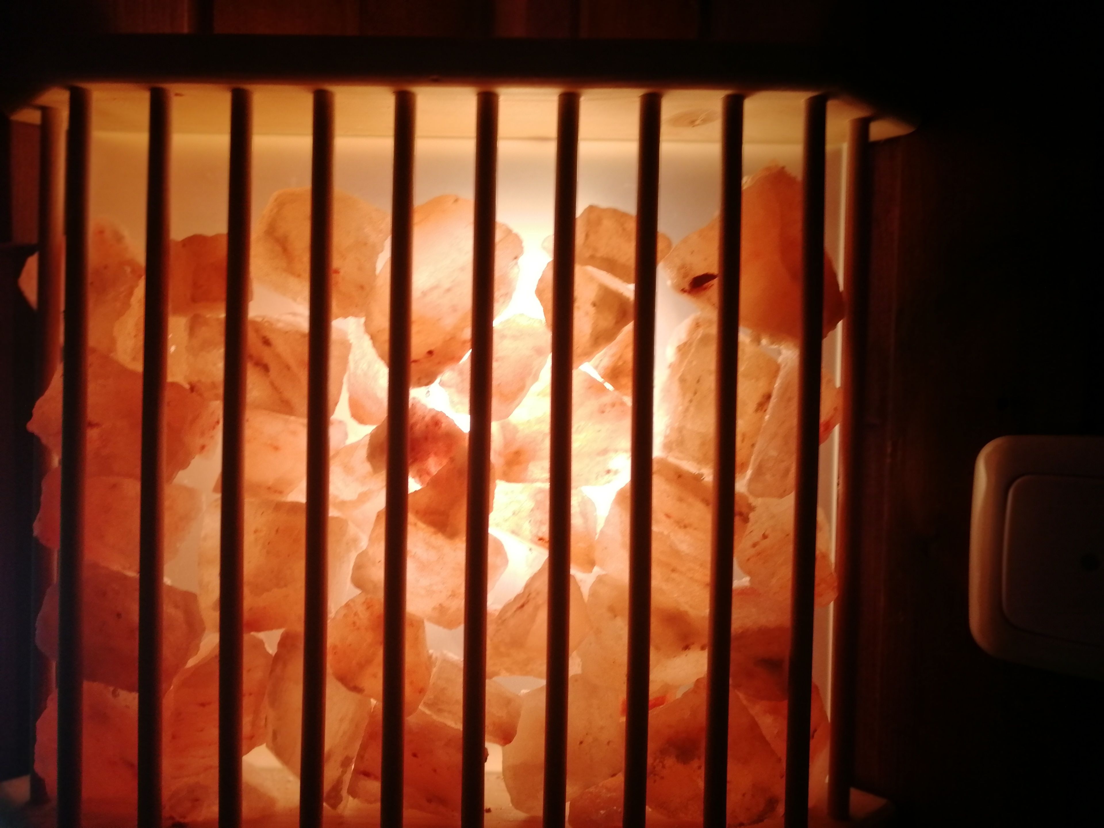 Eine Salzlampenleuchte mit Holzrahmen und Glaseinschub.