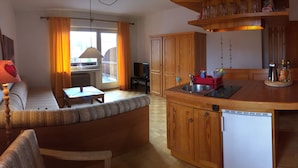 Una cocina acogedora con armarios de madera, lavavajillas integrado y un comedor con banco.