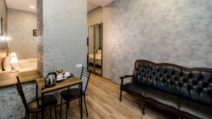 Una habitación moderna con una mesa de comedor de madera, un sofá de cuero negro y un espejo grande.