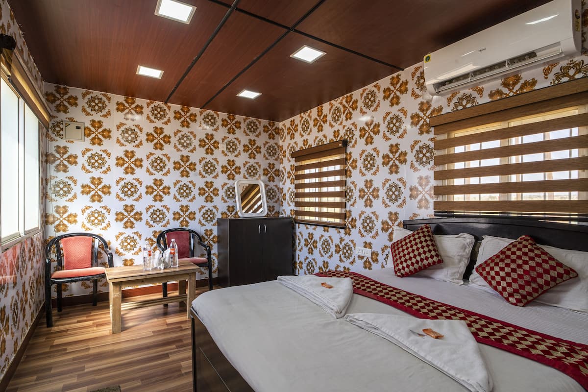 Una habitación de hotel con una cama, un escritorio, una silla y un armario.