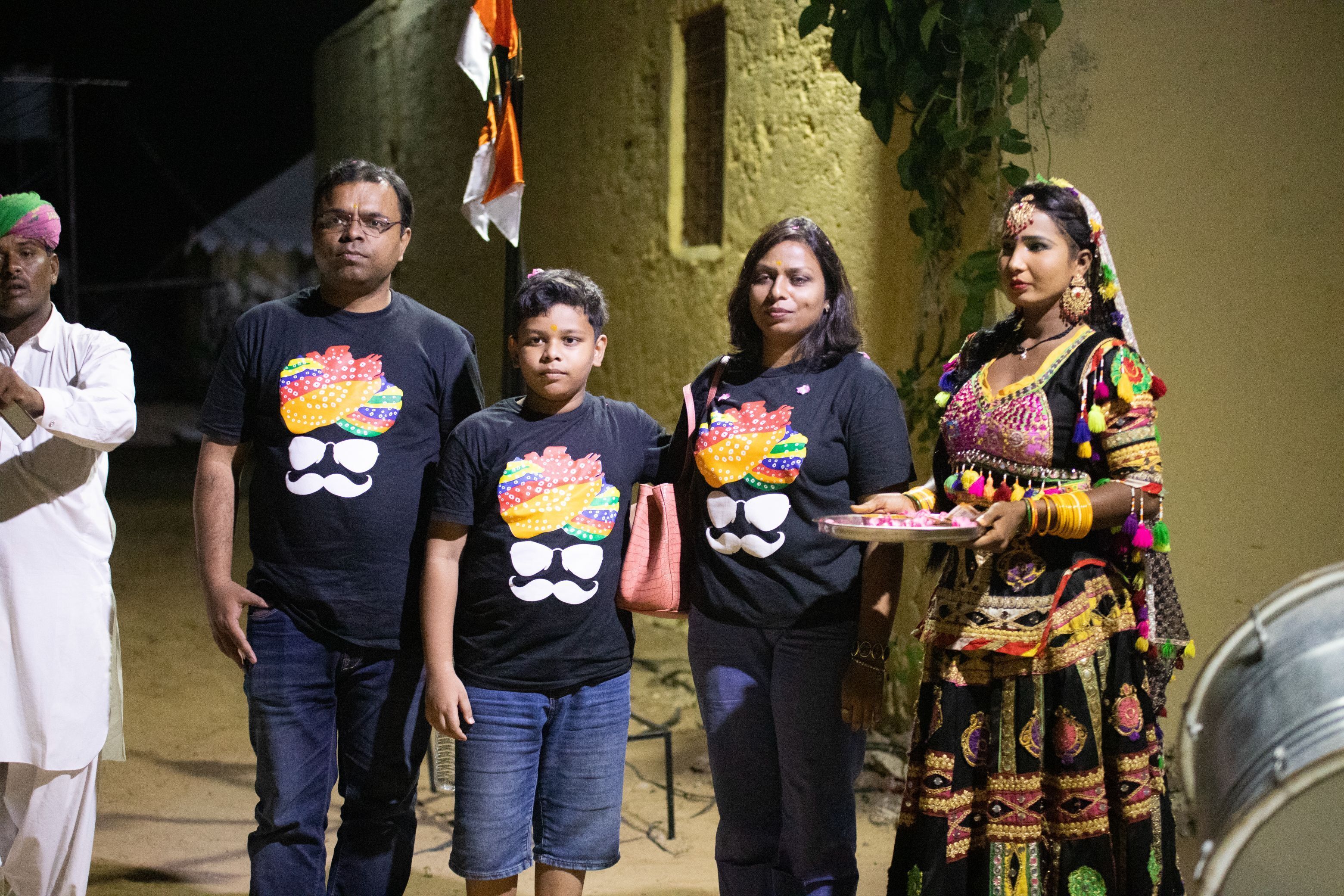 A group of people standing in an outdoor setting with a building in the background.