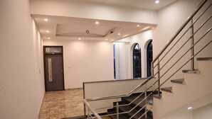 A modern interior with a staircase, a door with a decorative panel, and a tiled floor. - Winter Mountain Resort (Pushkar)