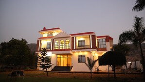 A two-story house with a balcony, large windows, and a well-lit entrance. - Winter Mountain Resort (Pushkar)