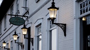 Une enseigne d’hôtel portant le nom « Flinchs Hotel » et plusieurs lampadaires suspendus.