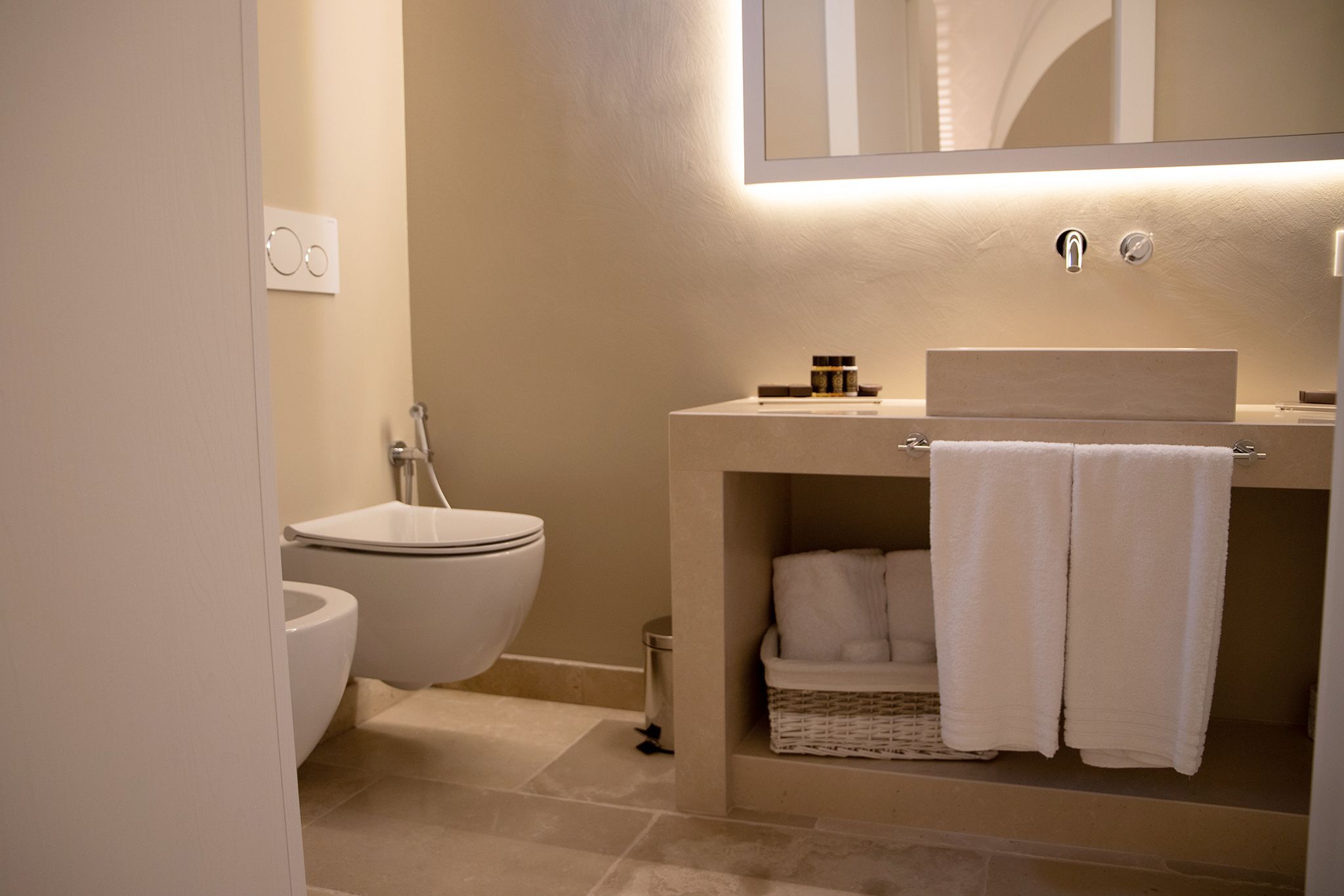 A modern bathroom with a toilet, sink, and towel rack.