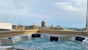 A hot tub with a view of historic buildings and a clear sky. - Monun Hotel & Spa  (Grottaglie)