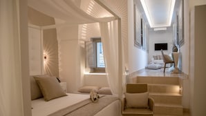 A modern hotel room with a bed, a chair, and a staircase leading to another room. - Monun Hotel & Spa  (Grottaglie)