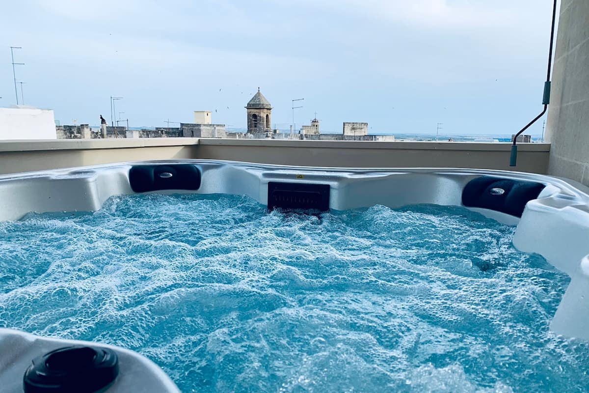 A hot tub with a view of a cityscape in the background.