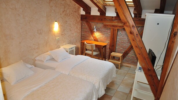 Een slaapkamer met twee bedden, een bureau en een witte inbouwkast.