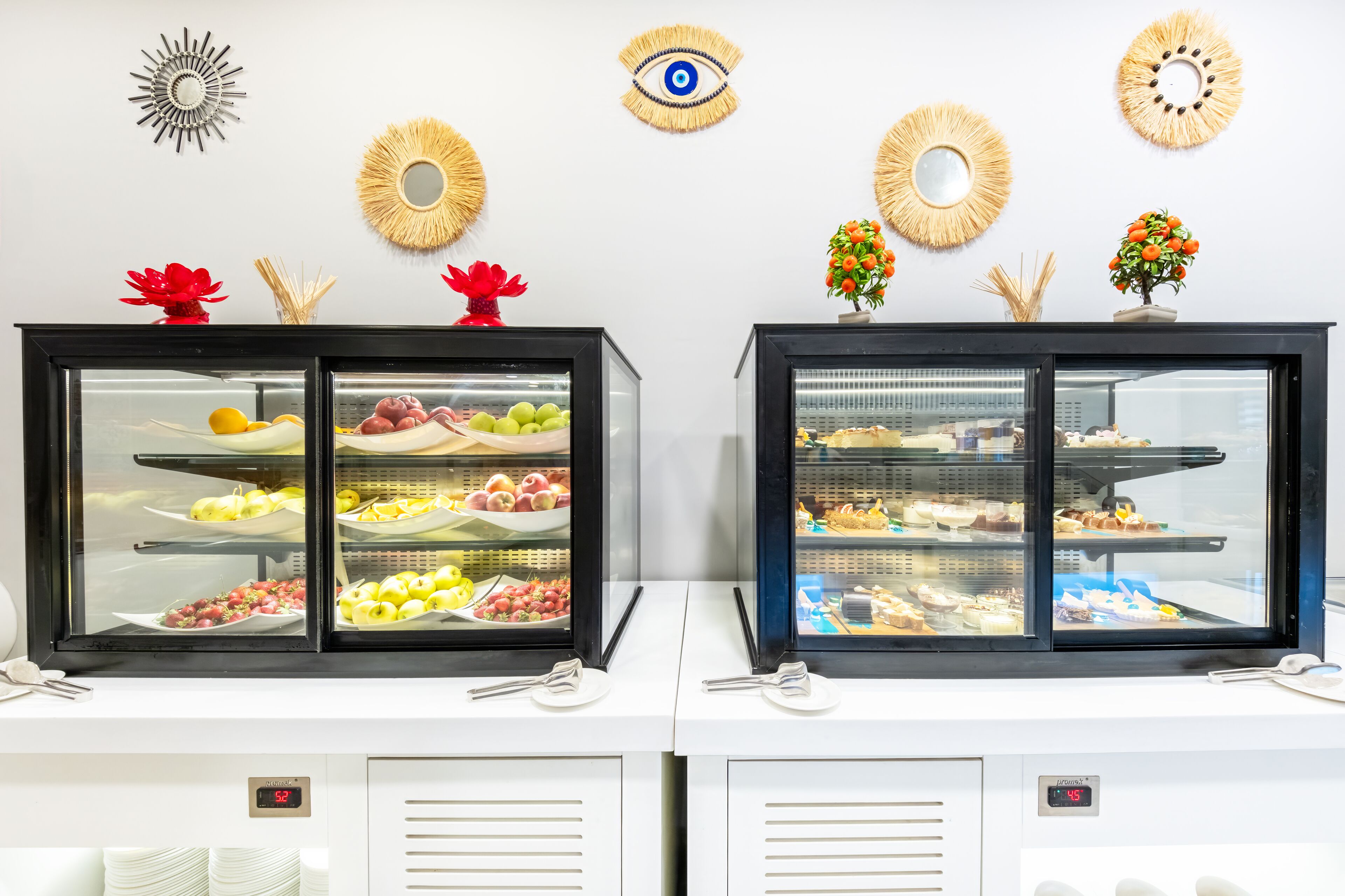 Two display cases with food items, a wall clock, and decorative wall art.