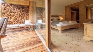 Un intérieur en bois avec un lit, un banc et un mur en verre.