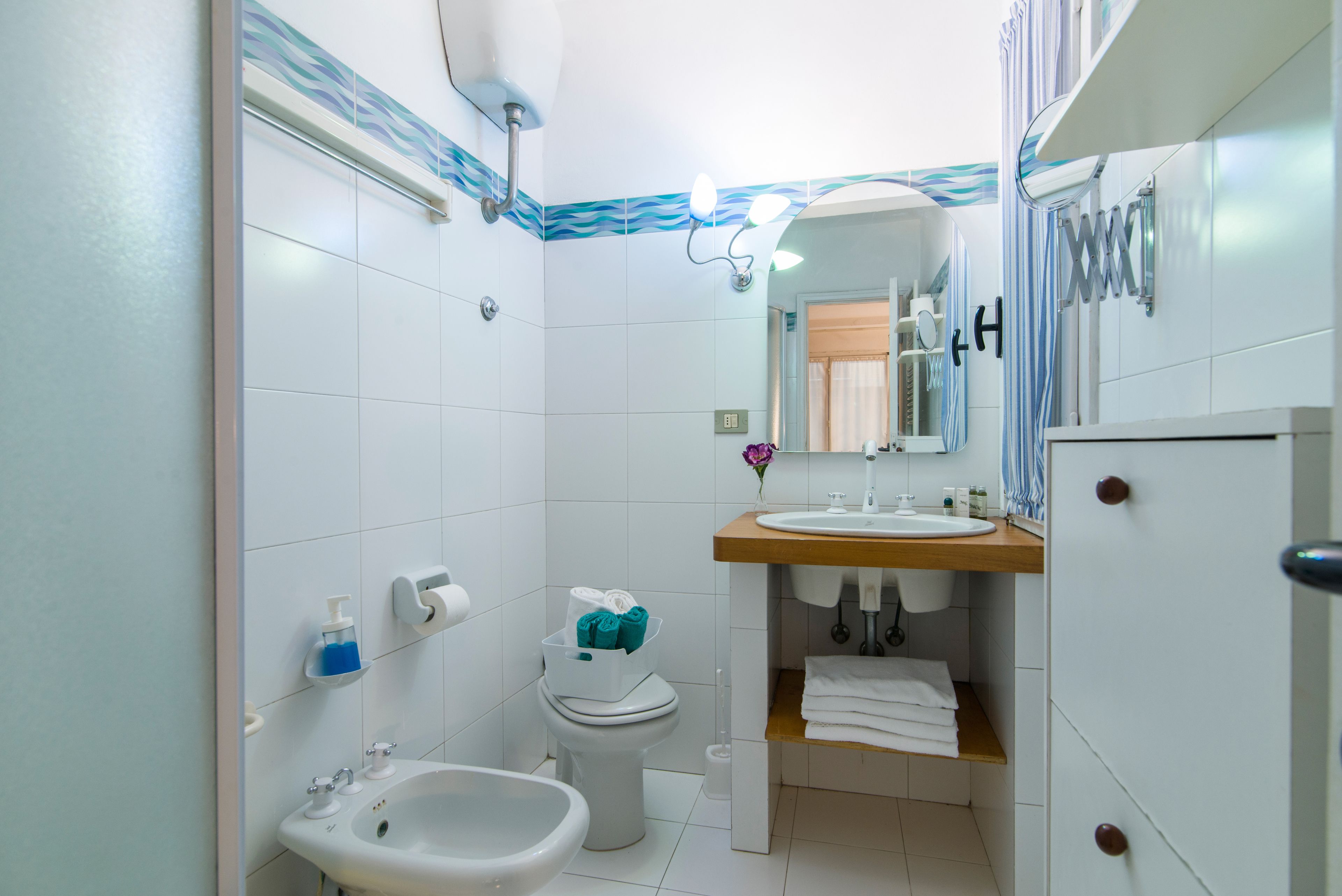 A modern bathroom with a sink, bidet, and toilet.