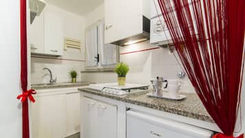 Apartamento, 1 quarto | Cozinha americana privada | Geladeira, cooktop, talheres/pratos/utensílios de cozinha