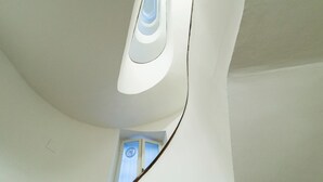 Un interior moderno con techo curvo y una puerta con un ventanal circular.