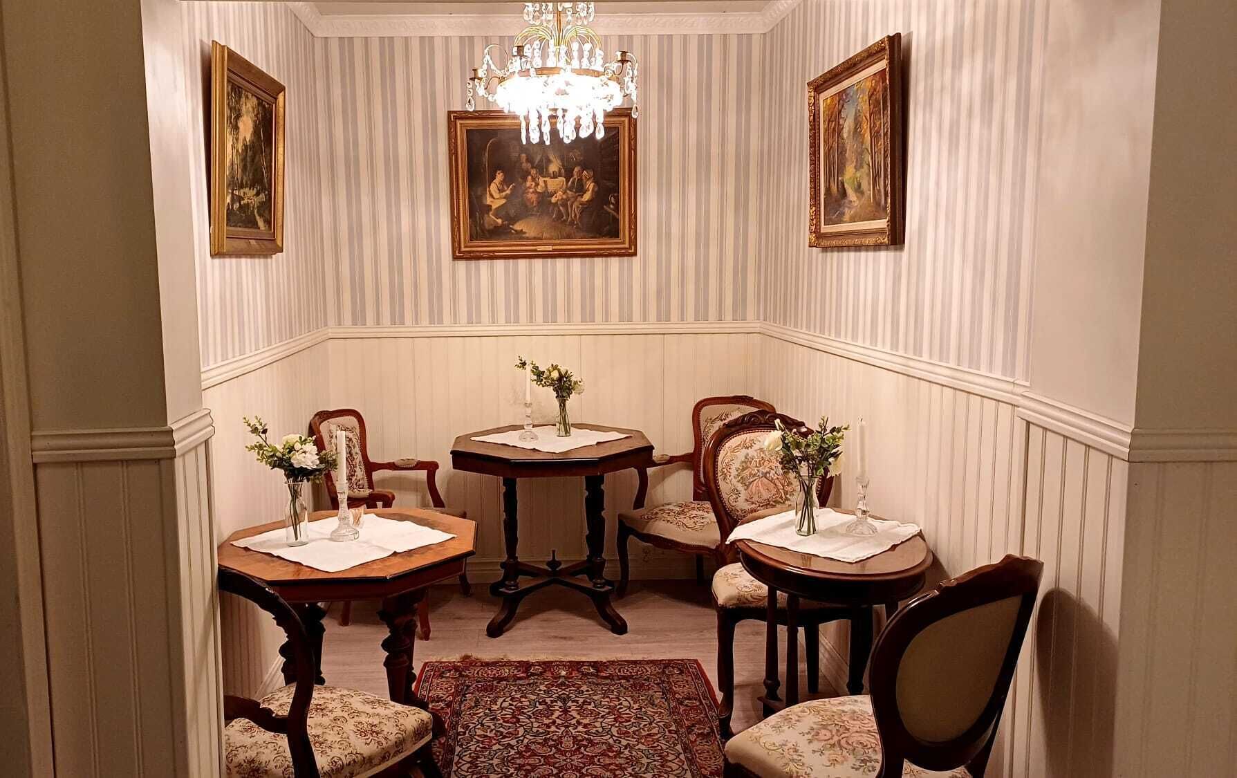 Comedor con candelabro, cuatro mesas de madera y sillas.