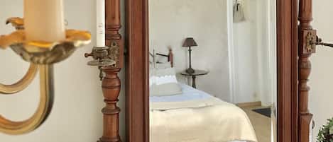 A mirror with a wooden frame, a bedside lamp, and a small potted plant.