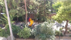 A playground with a yellow slide and a red and yellow climbing structure. - Comfortable apartment for your holidays, in the center of Athens. (Kallithea)