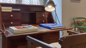 A wooden desk with a lamp, books, and a chair. - BEAUTIFUL APT DESIGN 1 BED SEVILLA CENTRO-FULL_AC (Sevilla)