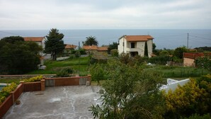 A residential area with houses, a paved patio, and a view of the sea. - Elba island. Panoramic house at the Zanca, 3 bedrooms, 8 pax. large outdoor area  (Zanca-sant'andrea)