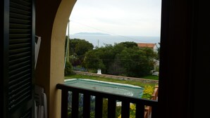 A balcony with a view of a swimming pool, greenery, and distant mountains. - Elba island. Panoramic house at the Zanca, 3 bedrooms, 8 pax. large outdoor area  (Zanca-sant'andrea)