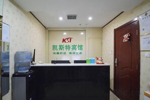 A reception area with a reception desk, chairs, a water dispenser, and a door with a teddy bear decoration.