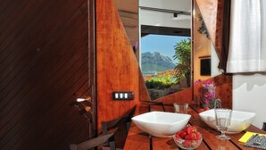 Un intérieur en bois offrant une vue sur un paysage montagneux par le biais d’une fenêtre.