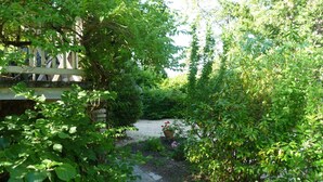 Un sendero en un jardín que conduce a un edificio con cerca de madera.