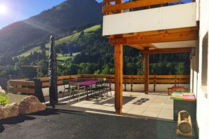 Une terrasse extérieure avec des meubles en bois, une table et un banc.