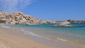 Une plage avec de gros rochers et une eau turquoise cristalline.