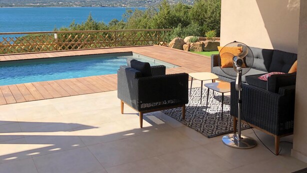 Un balcon avec une piscine, du mobilier d’extérieur et une vue sur les montagnes et un lac.