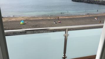 On the beach, black sand, beach towels