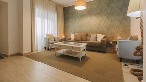 A modern living room with a sofa, coffee table, and a lamp. - Beach House by Azores Villas (Ponta Delgada)