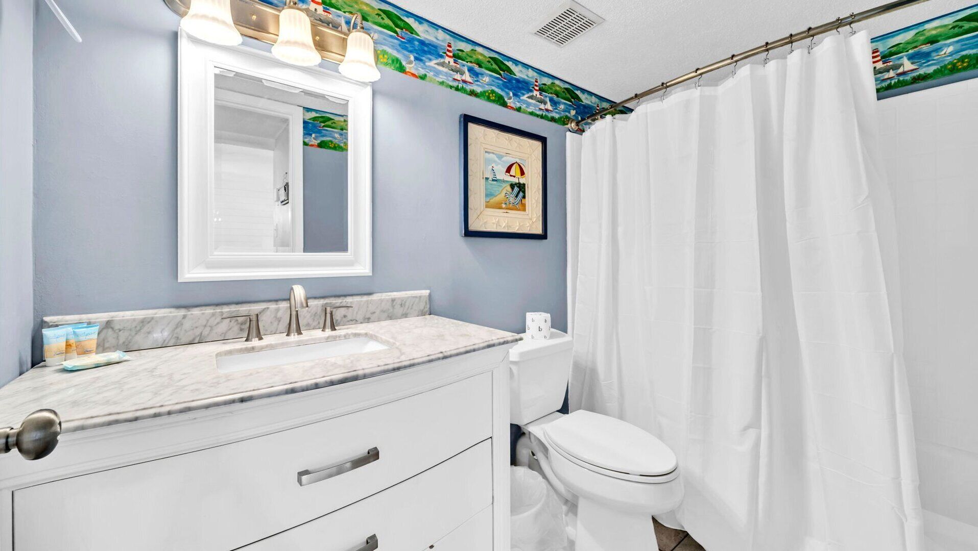 A bathroom with a marble countertop, a white toilet, and a shower curtain.