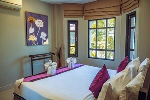 Ein Hotelzimmer mit einem großen Bett, einem Bild an der Wand und einem Fenster mit Blick auf Grünflächen.