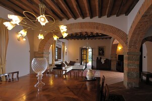 Un comedor con mesa de madera, sillas y un centro de mesa decorativo de vidrio.